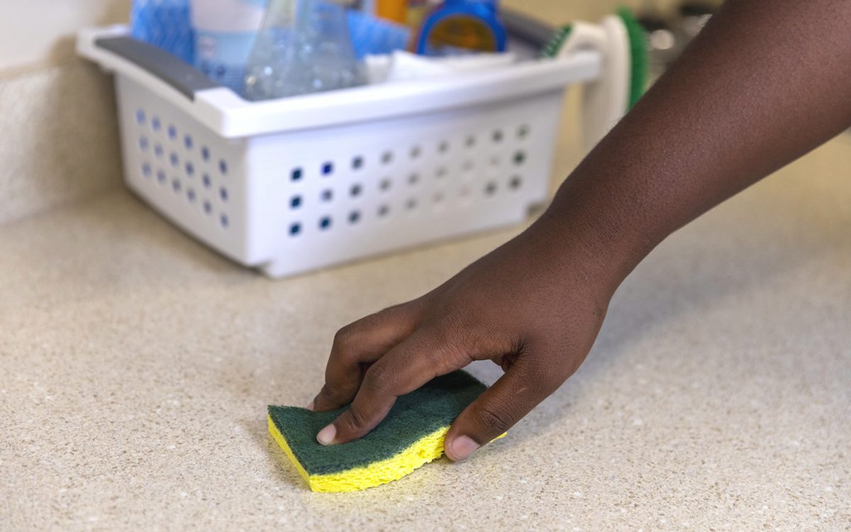 Wiping down a kitchen counter by hand